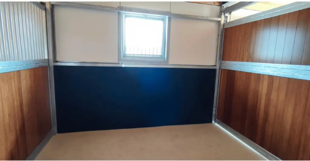 Zwarte rubber wandbekleding op maat gesneden onder een raam, tussen houten wanden